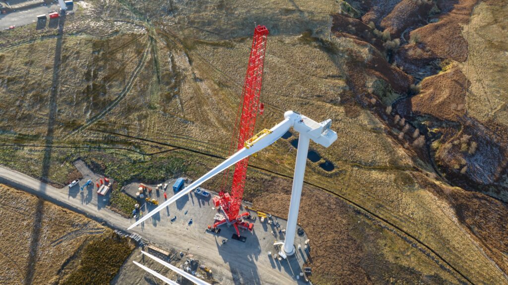 Aerial view of a crane installing a wind turbine at Sandy Knowe Wind Farm